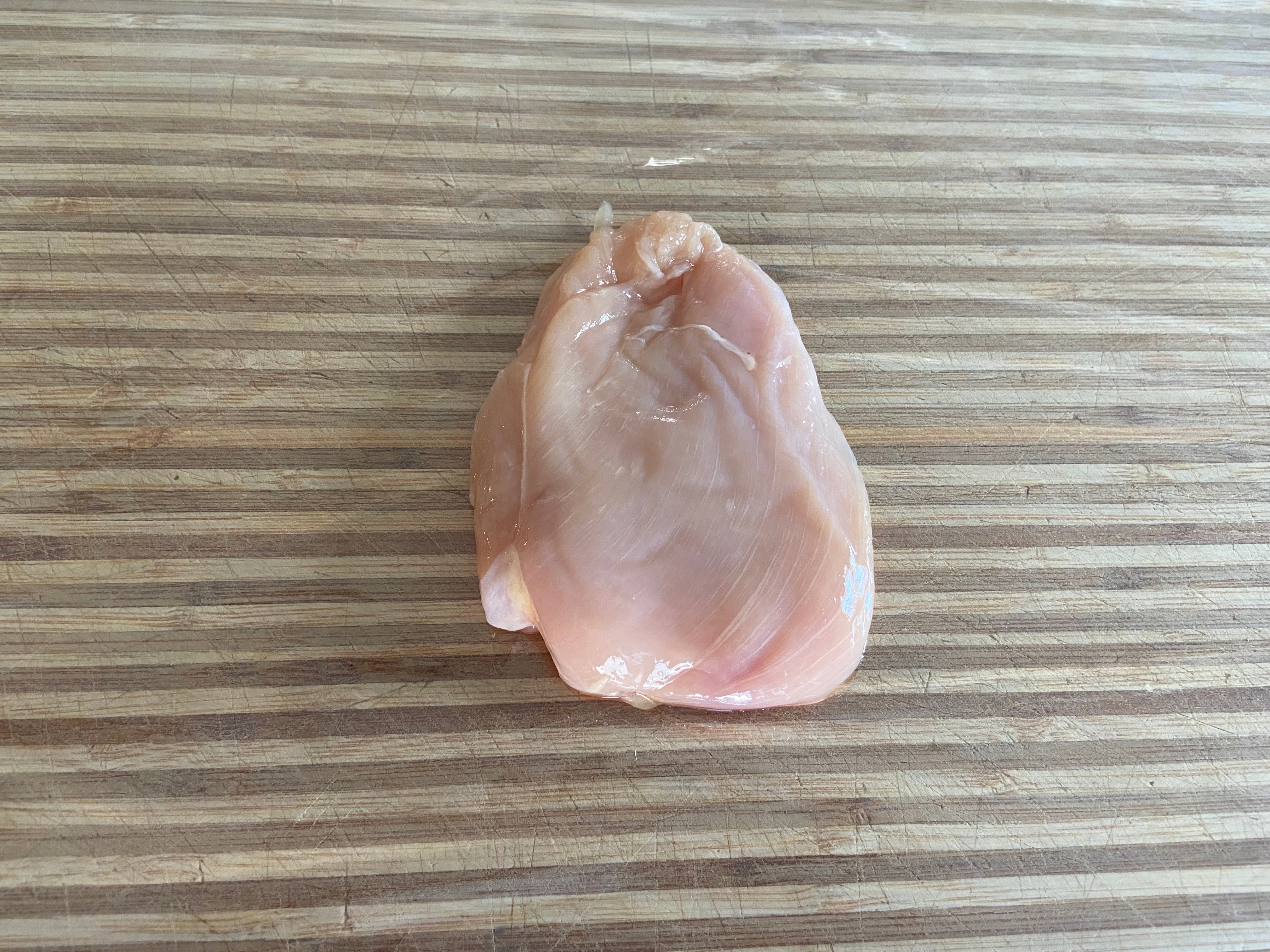 chicken cutlet placed on a cutting board