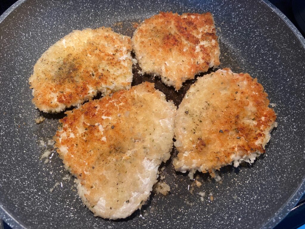 Chicken cutlets added to pan to cook