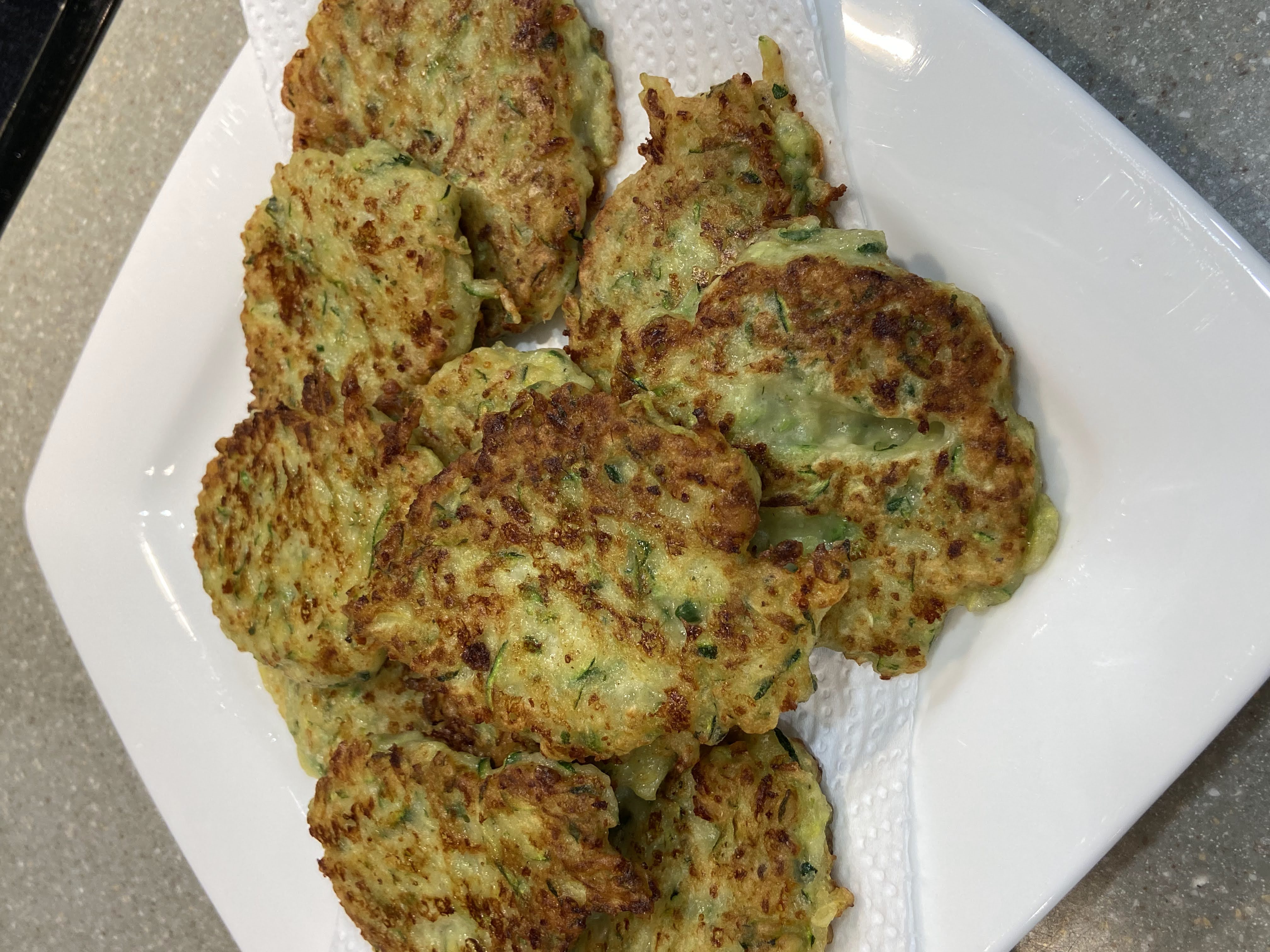 Zucchini fritters,
Zucchini fritters served on a plate