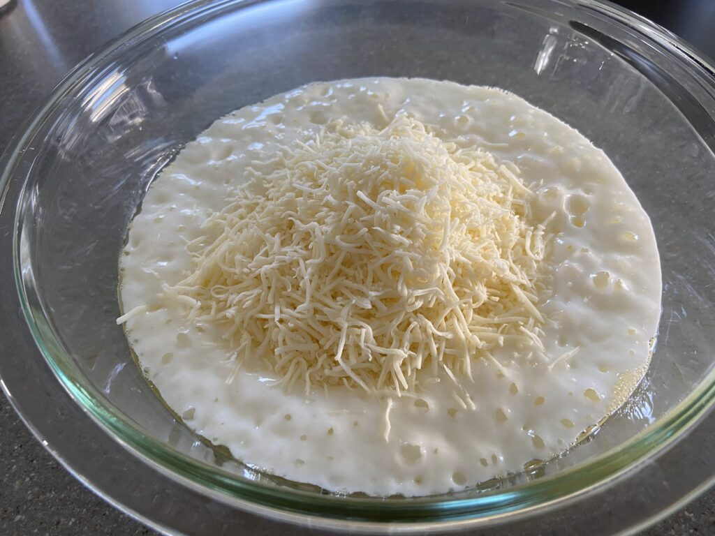 yogurt, cottage cheese, eggs, and shredded cheese are added to a bowl.