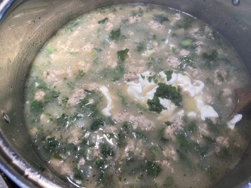 cream cheese and sour cream added to pot of chicken sausage, kale and potatoes soup