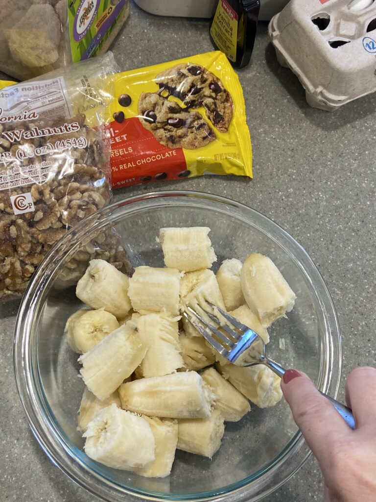 bananas mashed with fork in a bowl 
