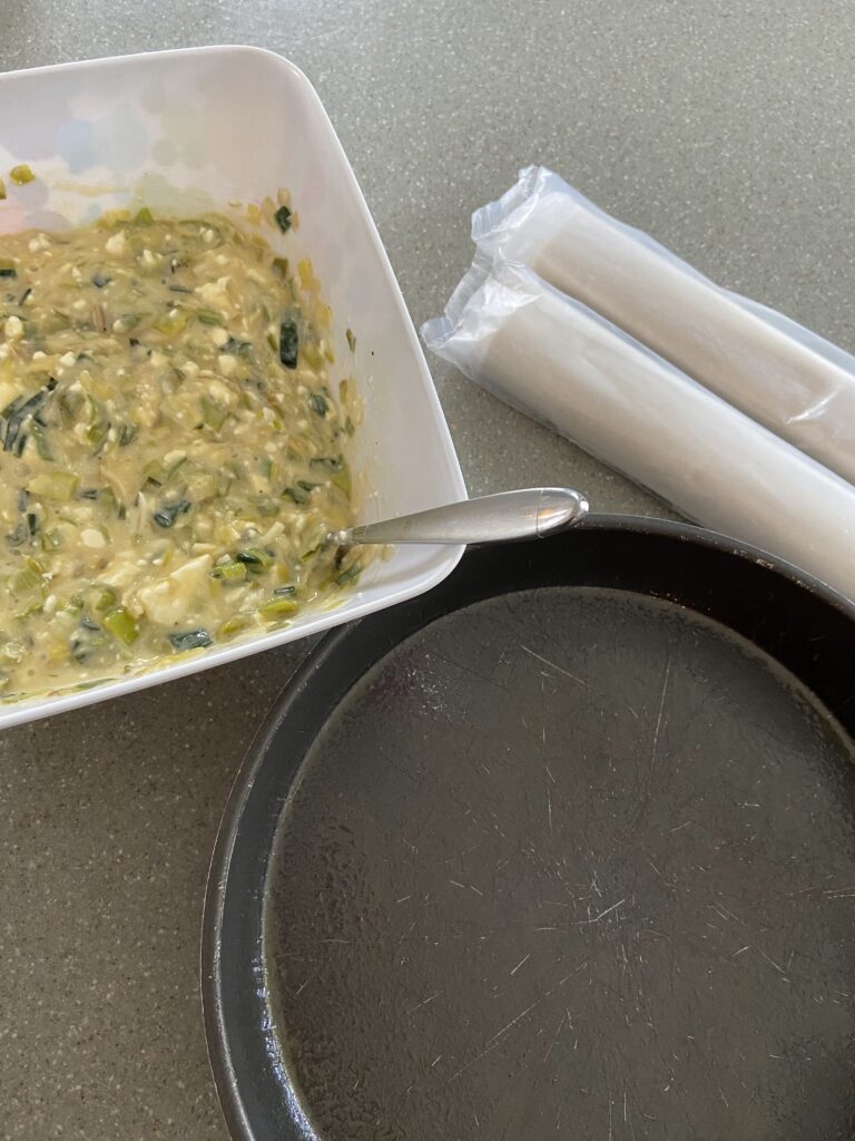 round baking pan
rolls of phyllo dough sheets
prasopita
leeks and feta cheese