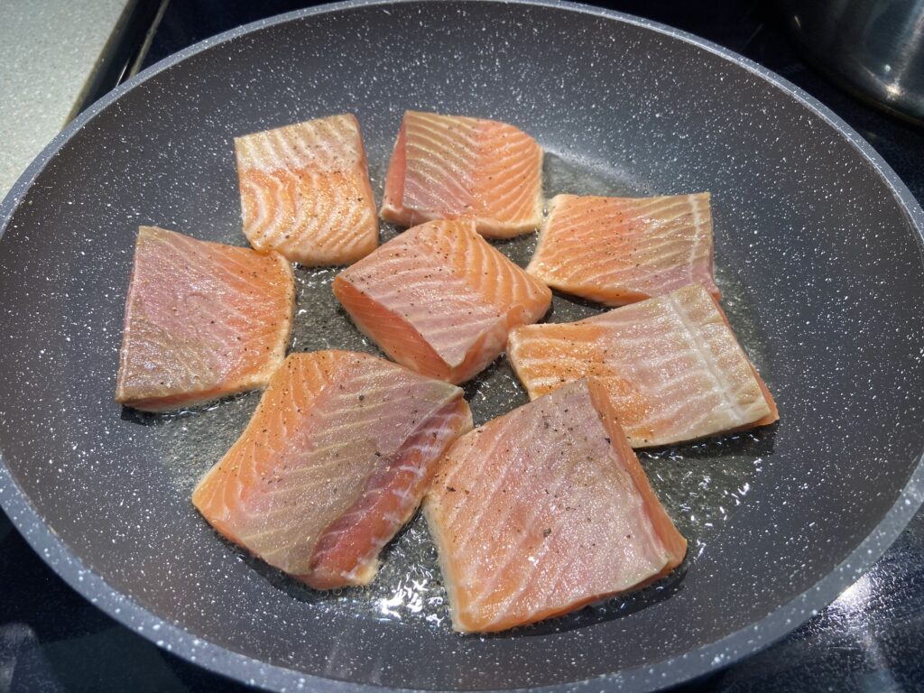 salmon fillet seasoned side down in the pan, pan seared salmon without skin