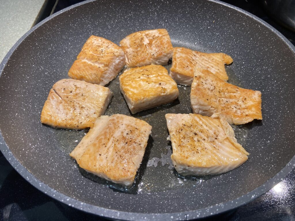 salmon fillet seasoned side down in the pan, pan seared salmon without skin