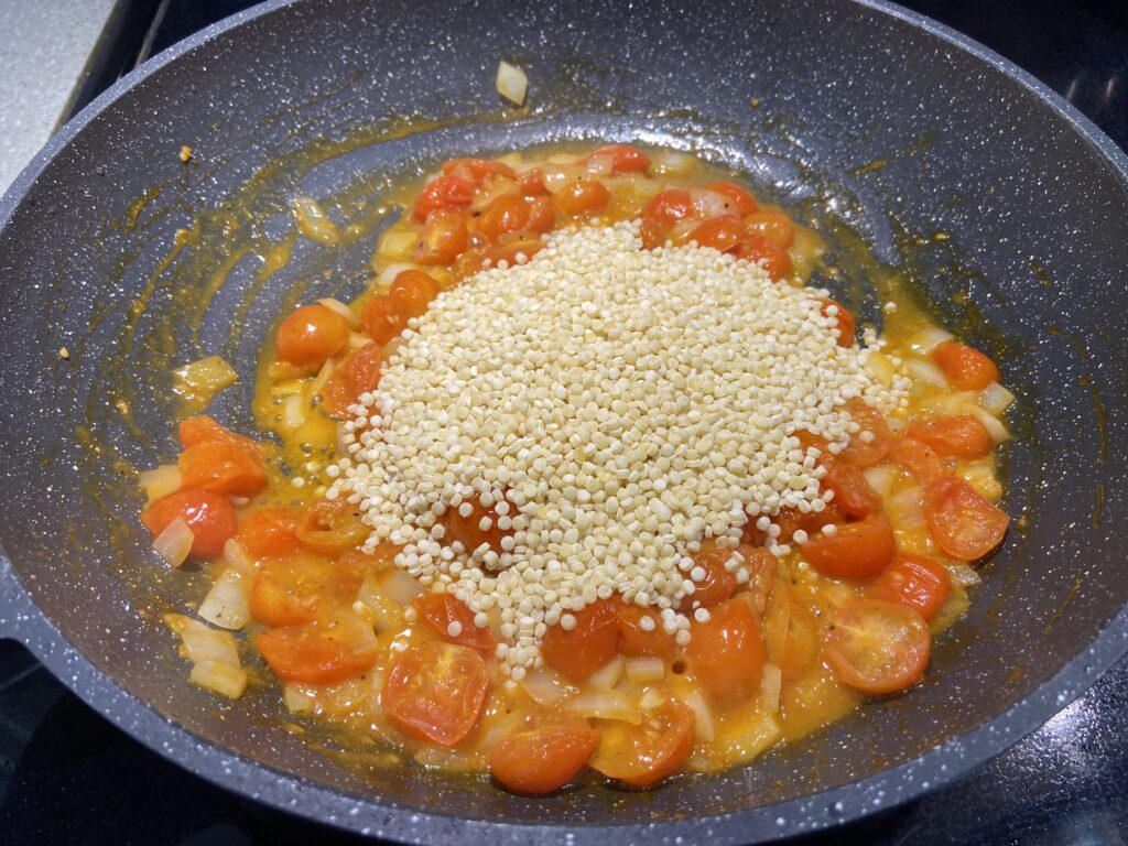 blistered cherry tomatoes with chopped onion and couscous