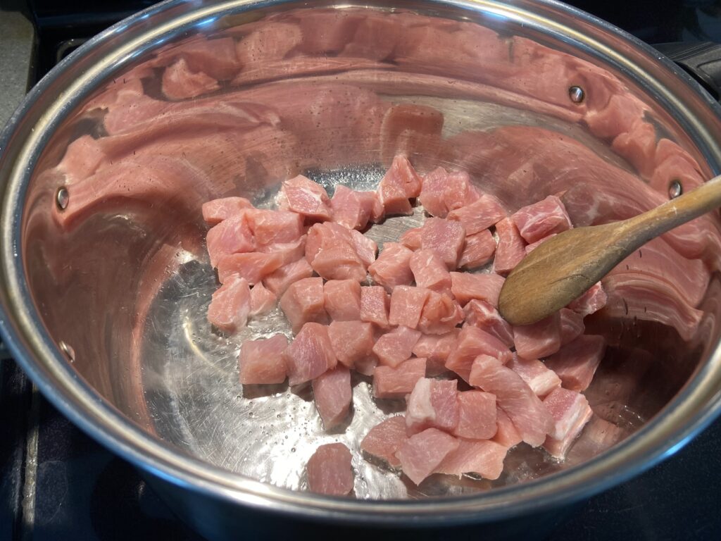 pork cubes added to a pot with olive oil and sauteed until golden brown on all sides