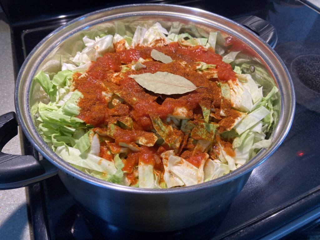 seasonings added to a pot of cabbage