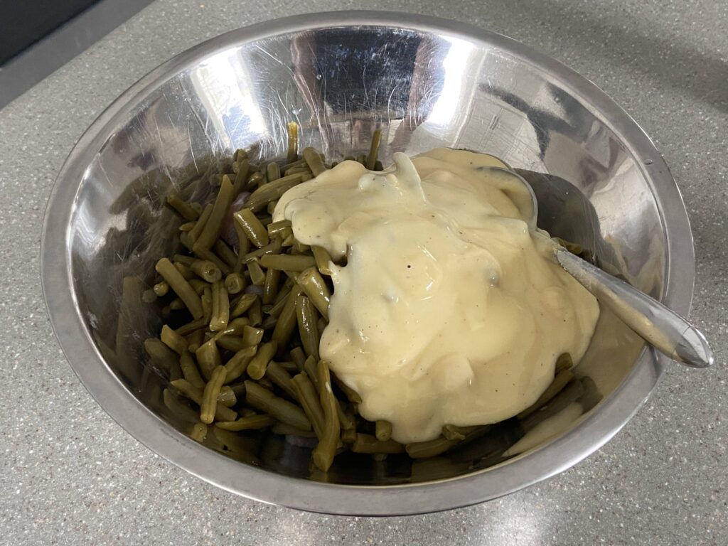 chicken breasts in baking dish for green bean casserole

mixing cream of chicken soup and green beans

baked chicken green bean casserole in pan